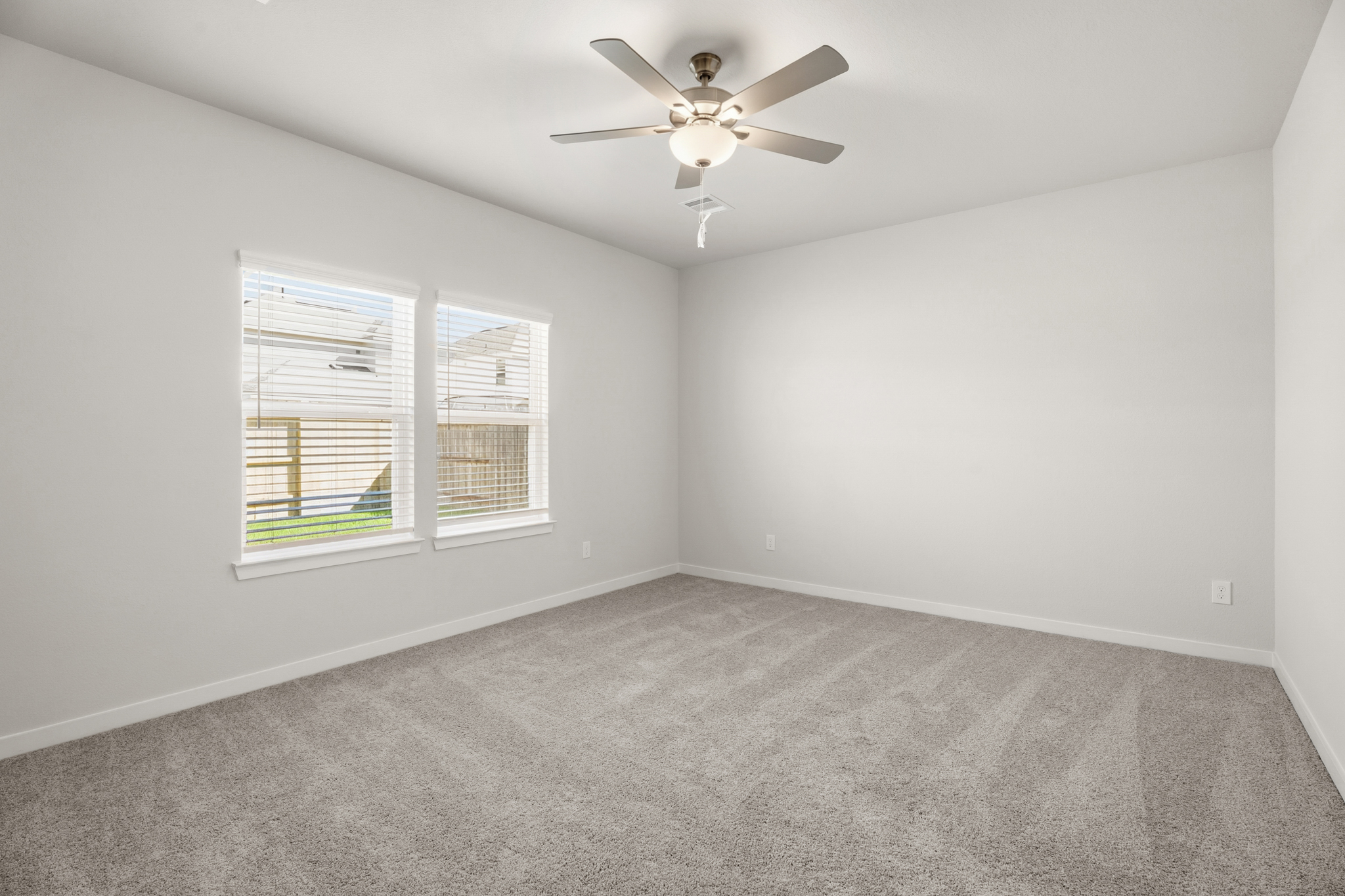 A room with a ceiling fan and a window.