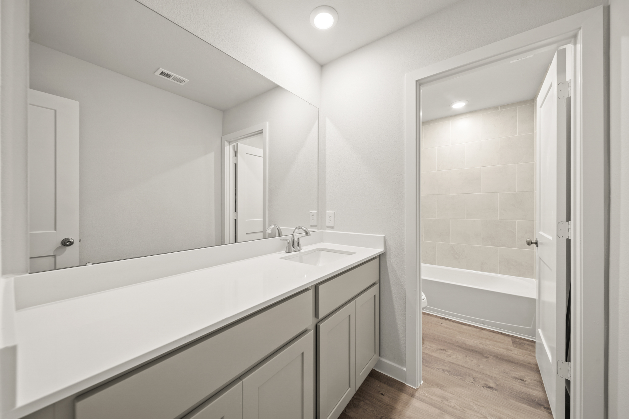 A bathroom with a tub sink and shower.