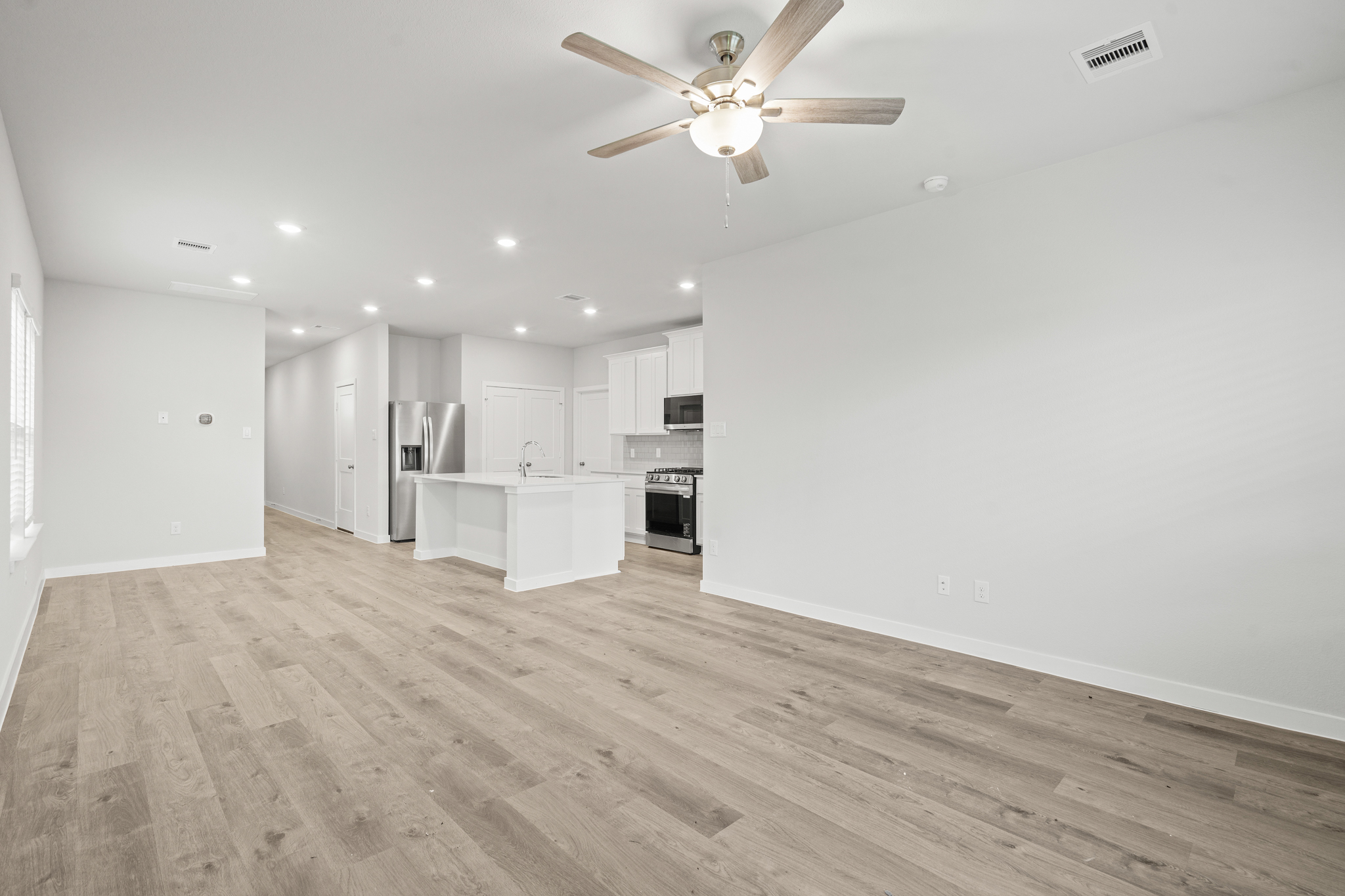A large kitchen with a wood floor.