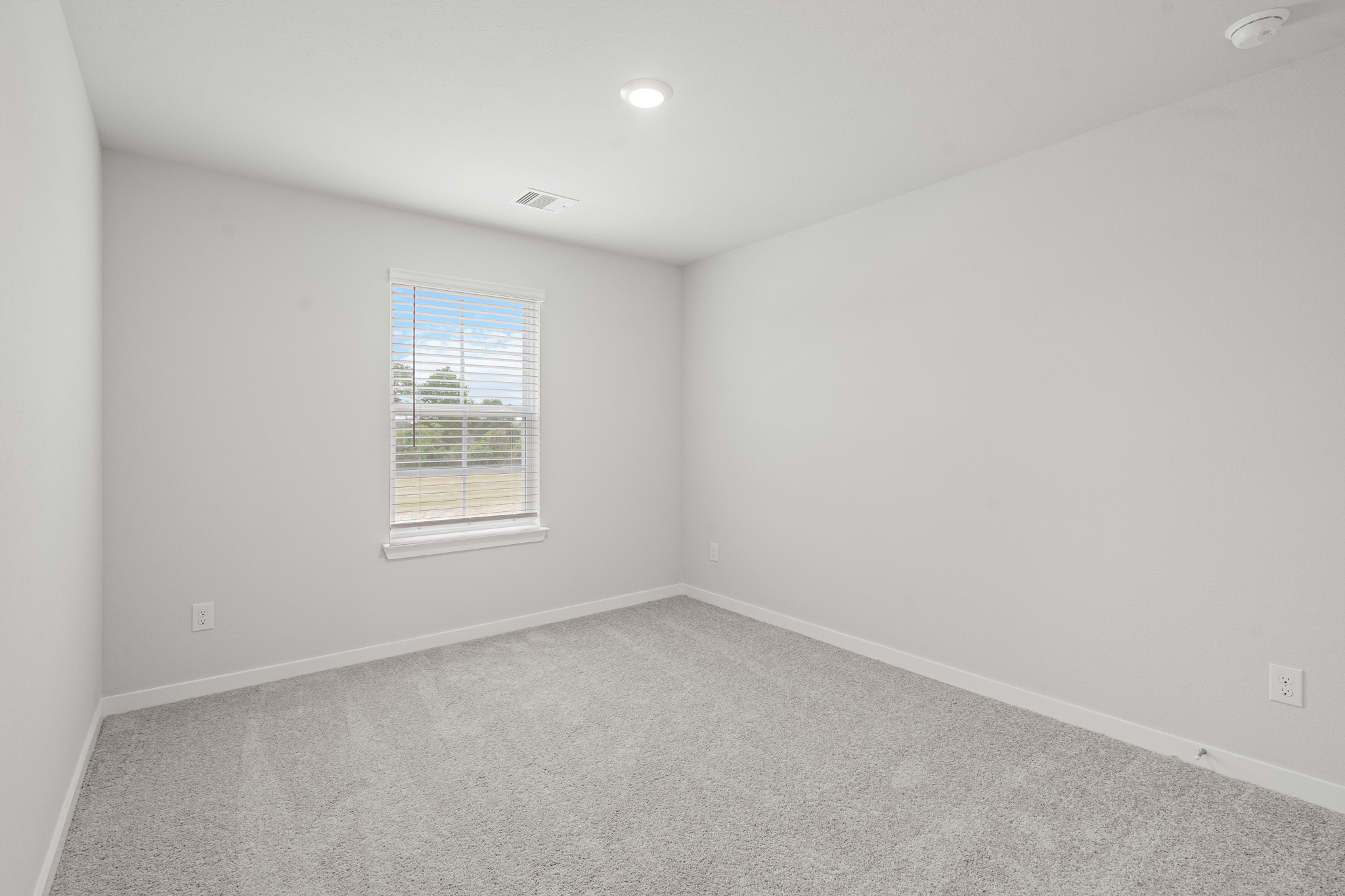 A room with a window and a carpet.