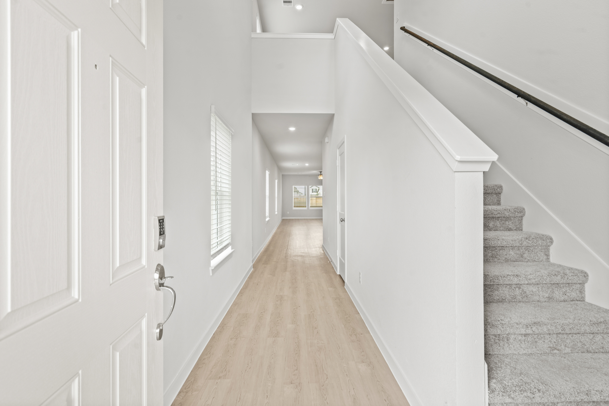 A long hallway with white doors.
