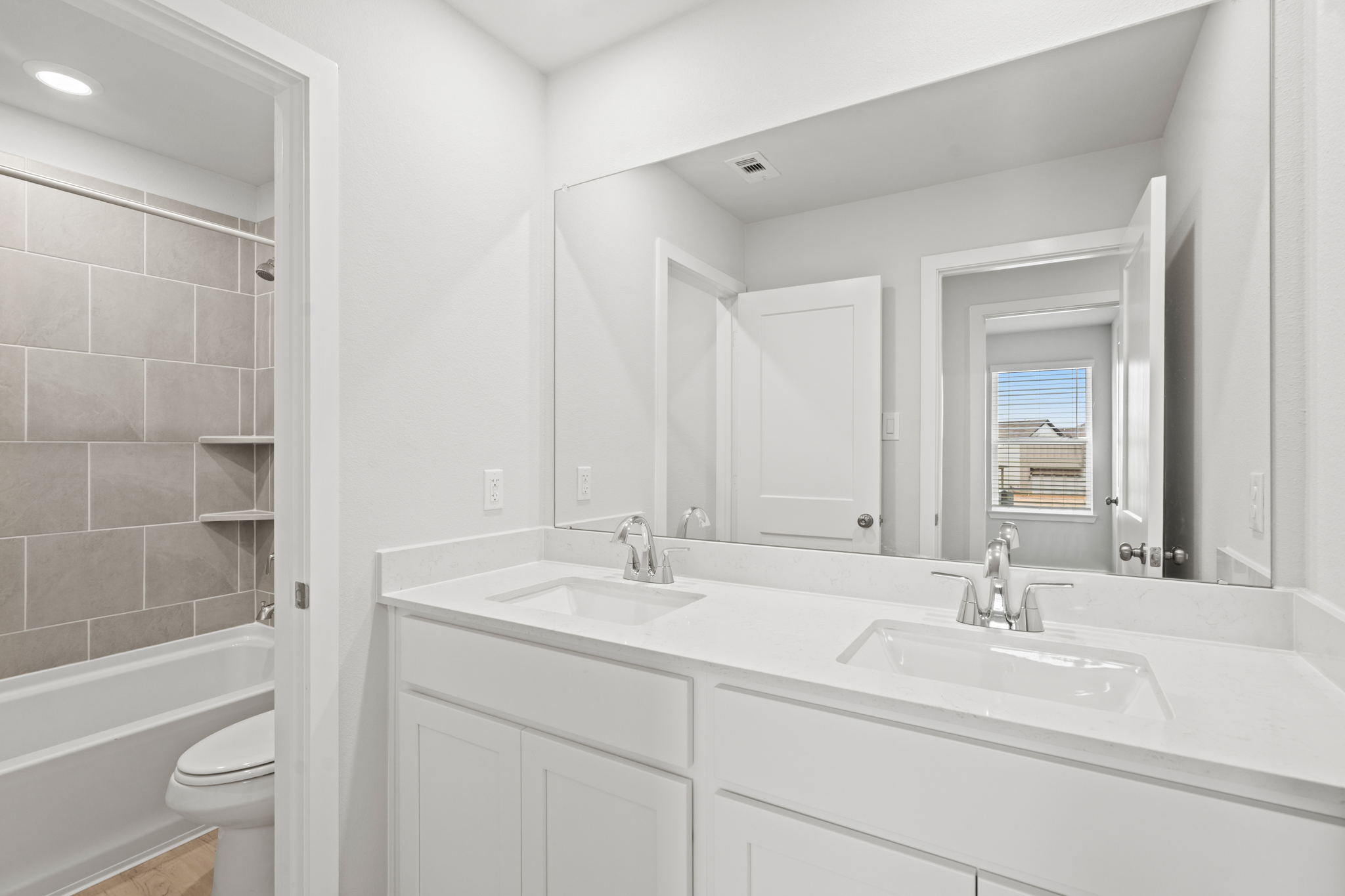 A bathroom with a large mirror.