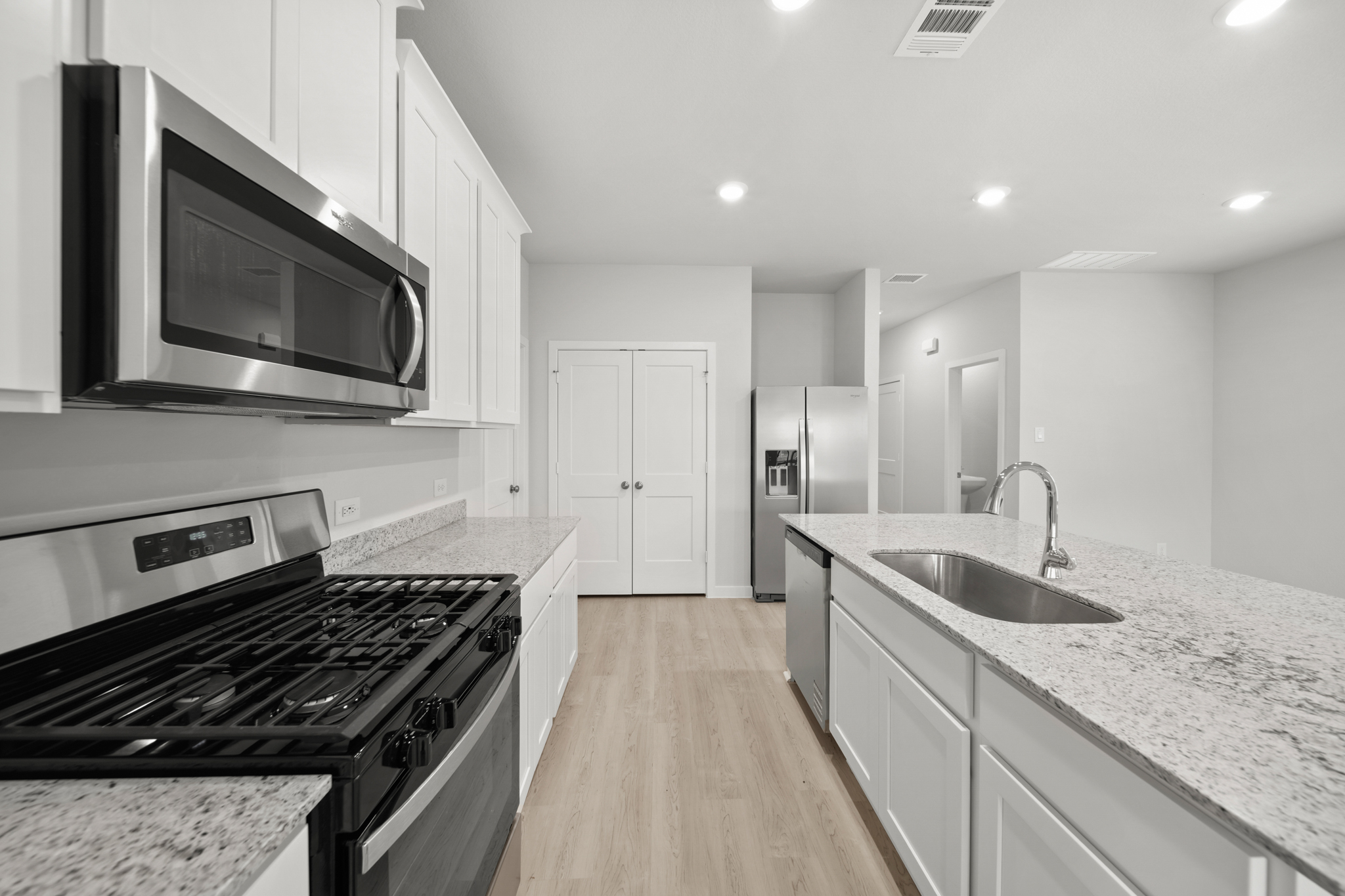 A kitchen with white cabinets.
