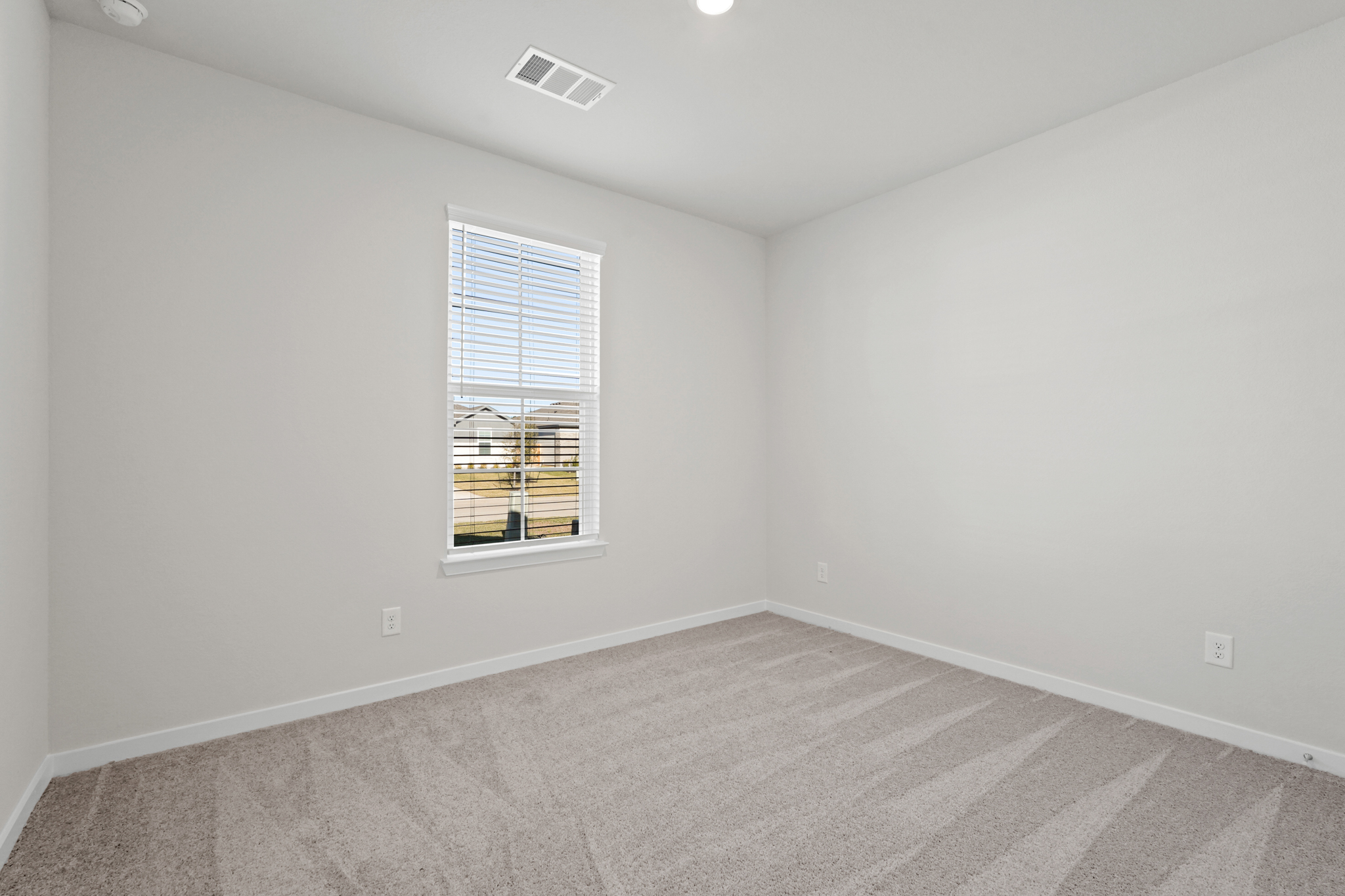 A room with a window and a carpet.