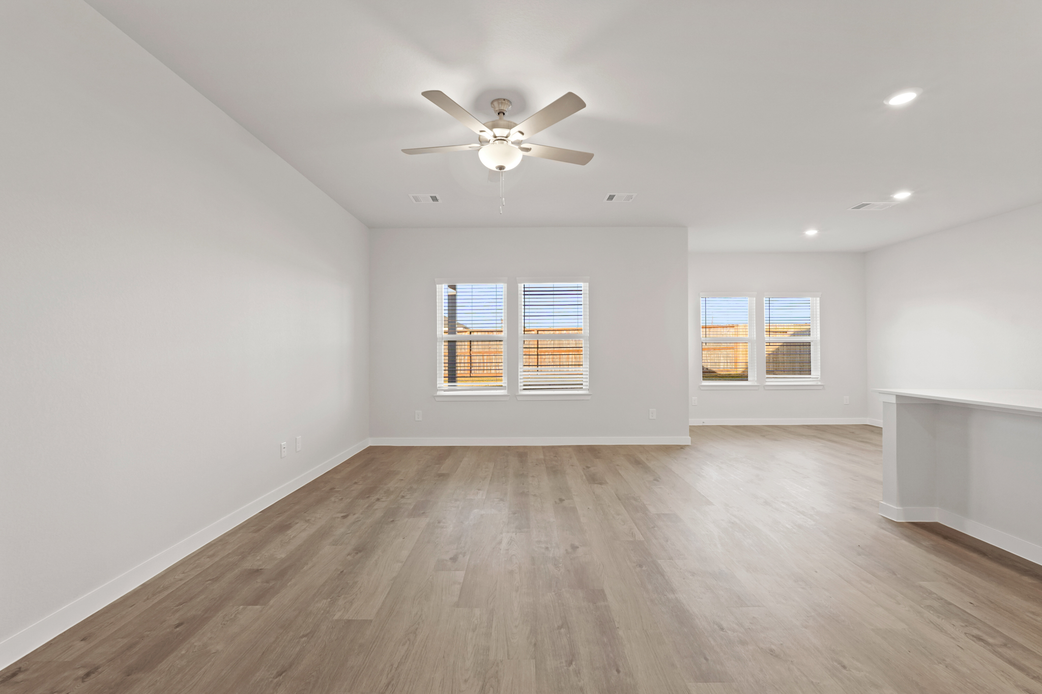 A room with a wood floor and a ceiling fan.