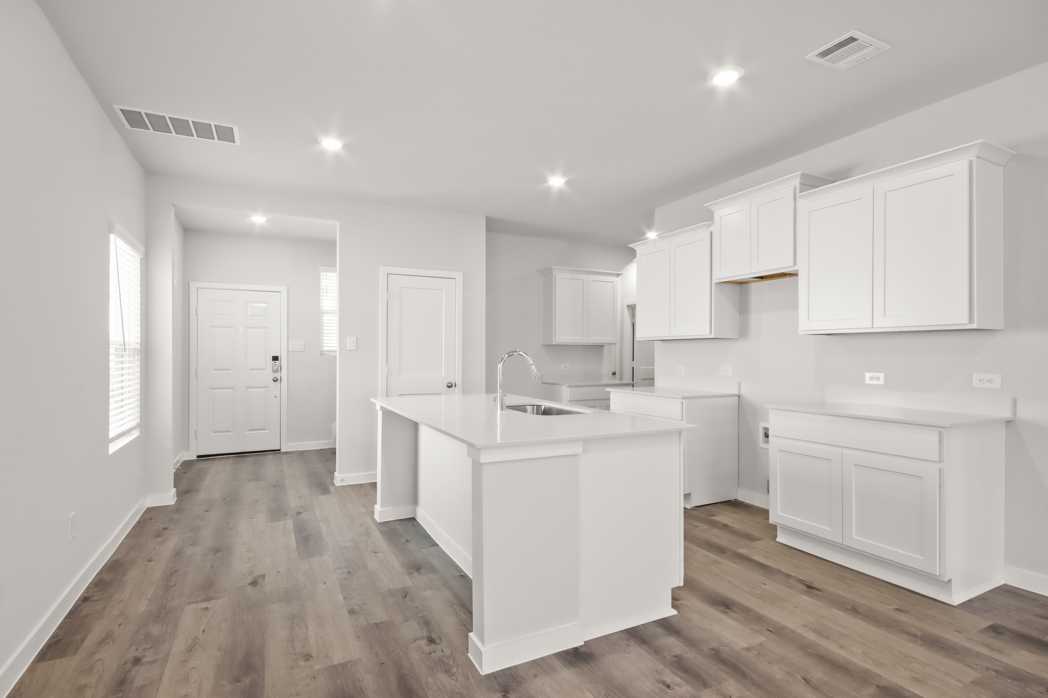 A kitchen with white cabinets.