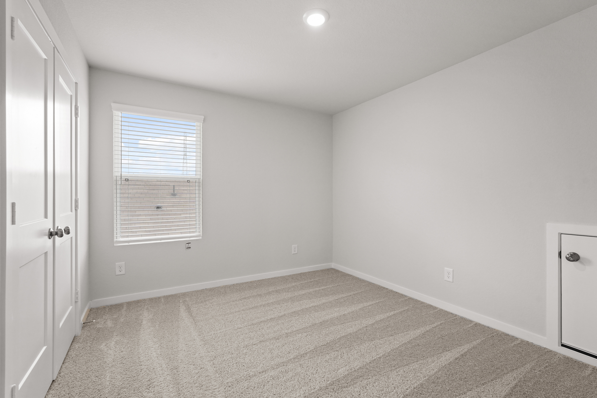 A room with a carpet and a window.