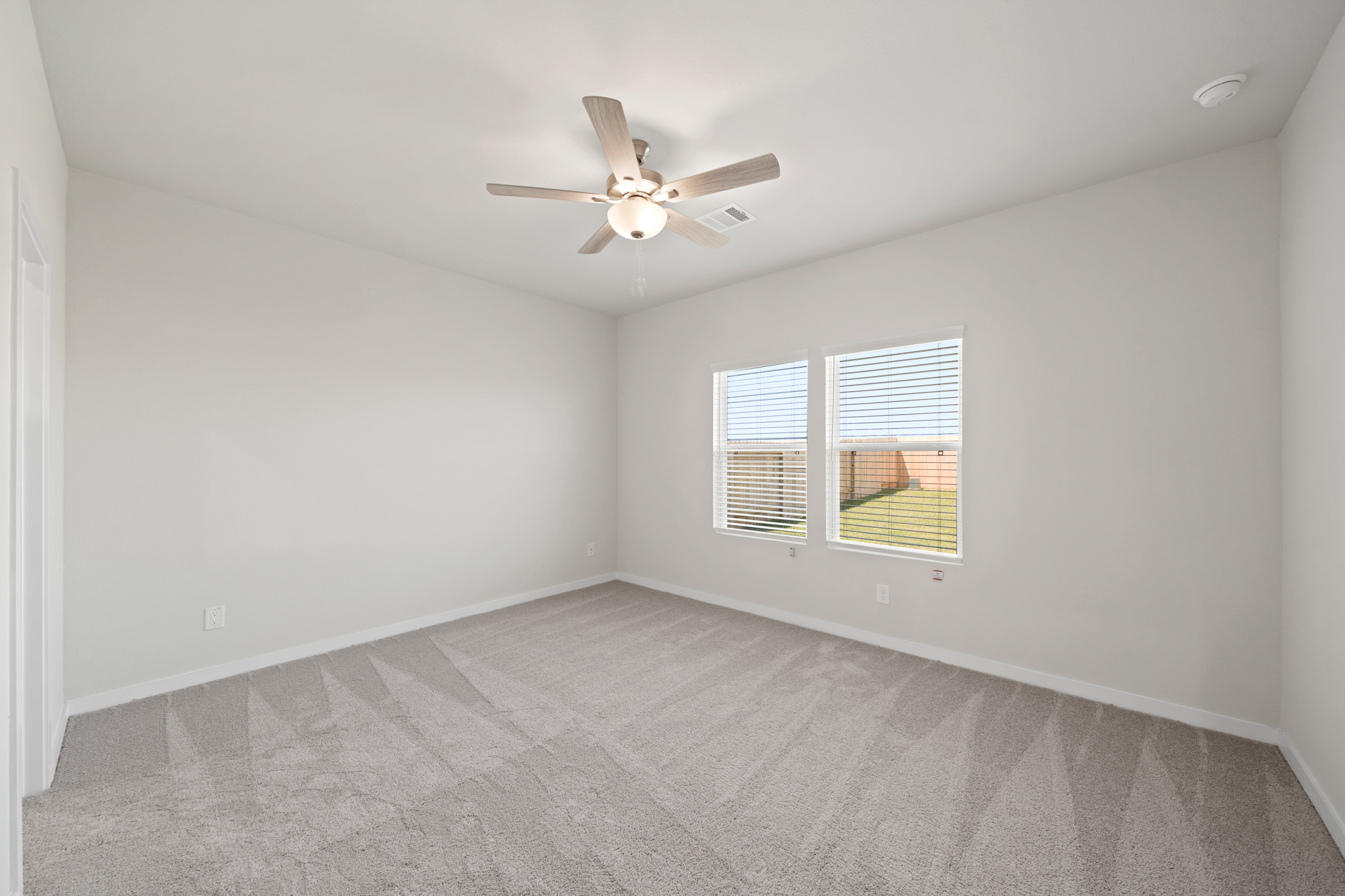 A room with a ceiling fan and a window.