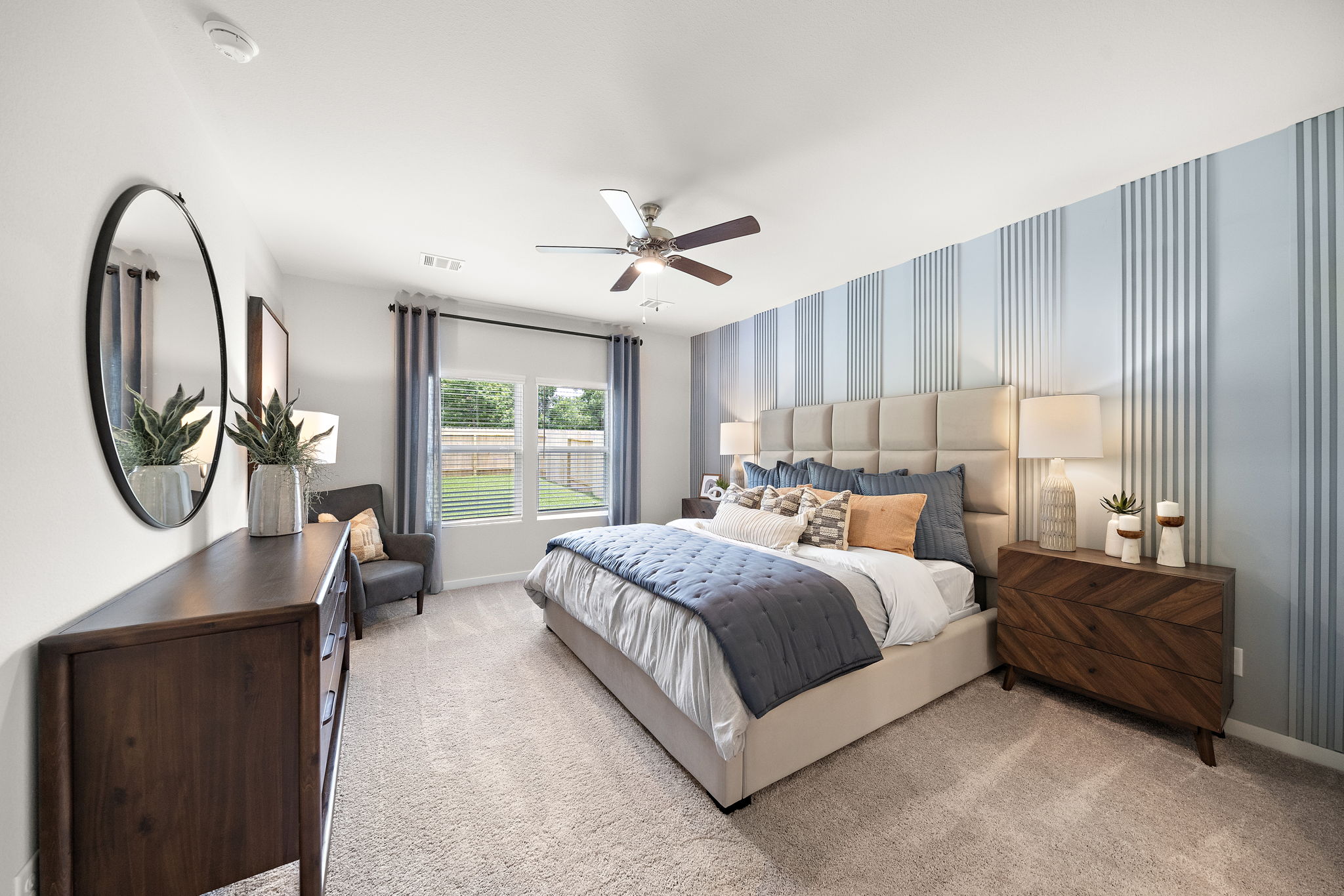 A bedroom with a bed and a mirror.