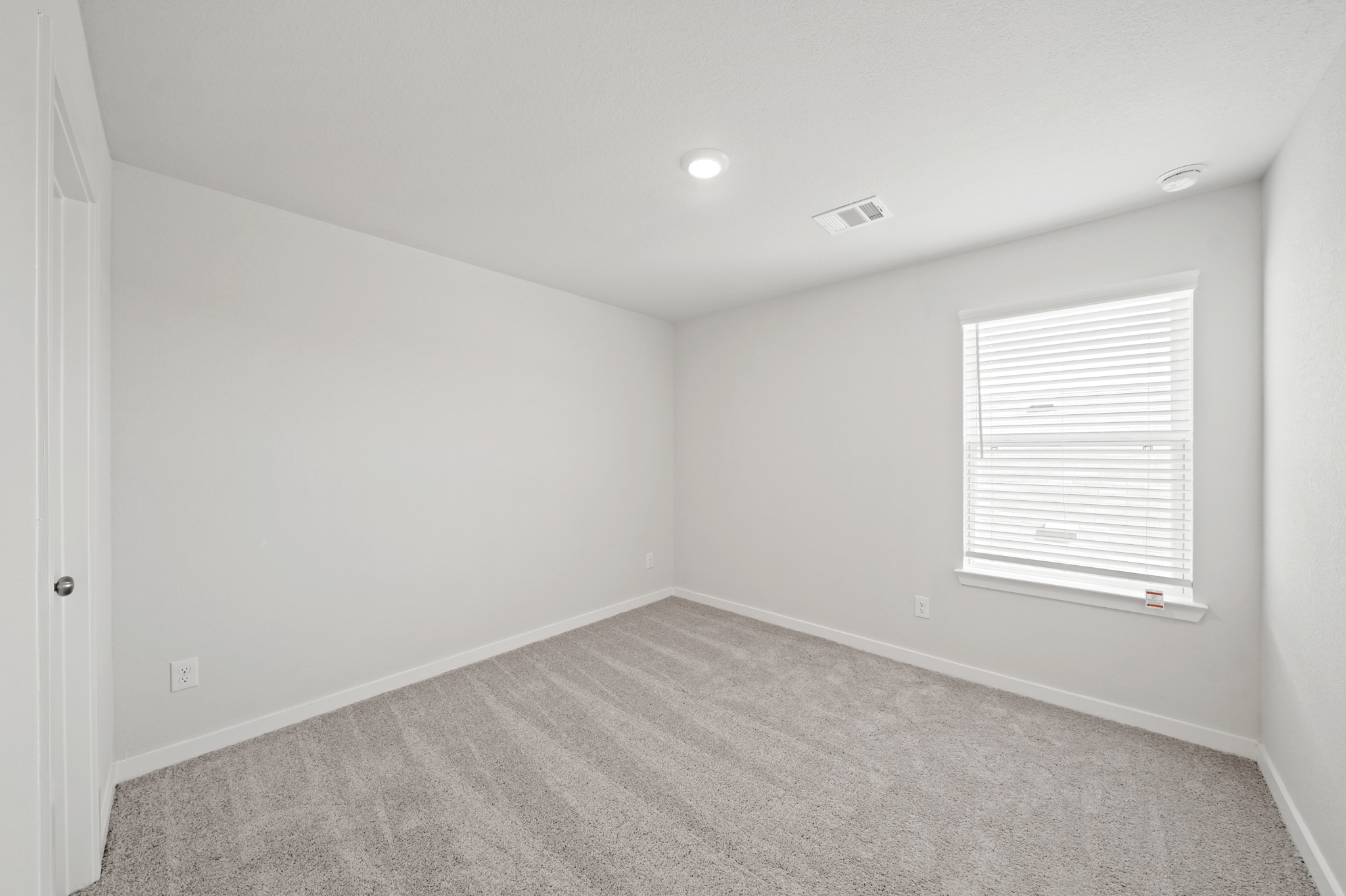 A room with a carpet and a window.