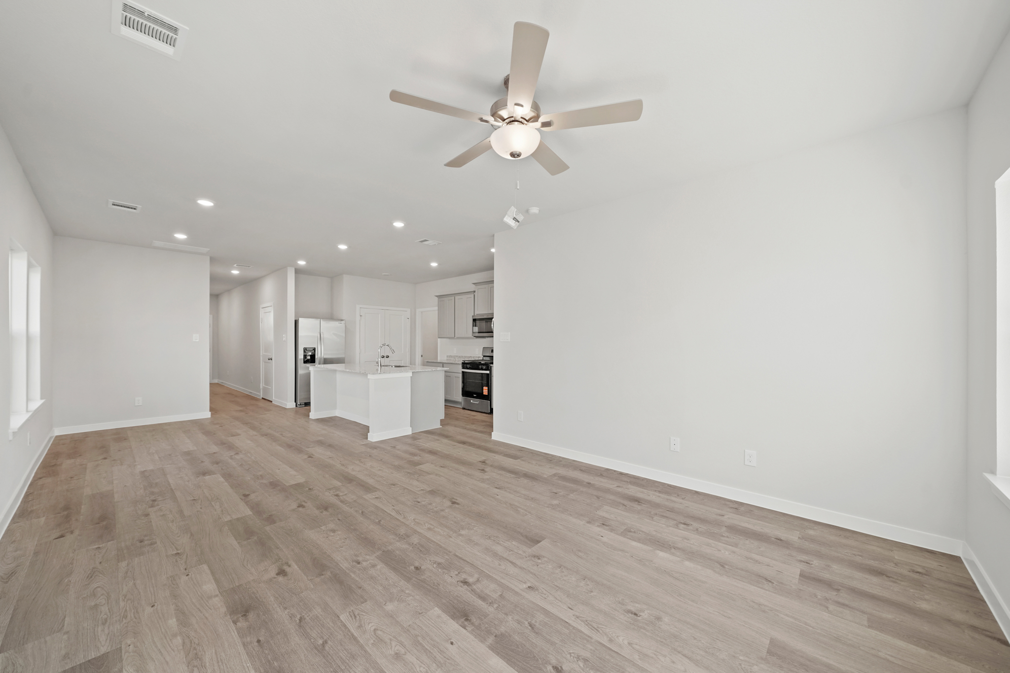 A large kitchen with a wood floor.