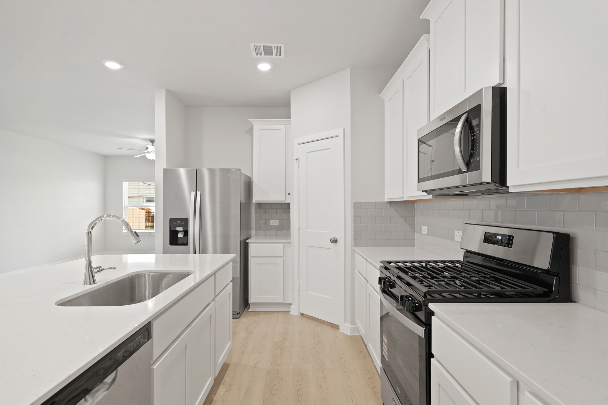 A kitchen with white cabinets.