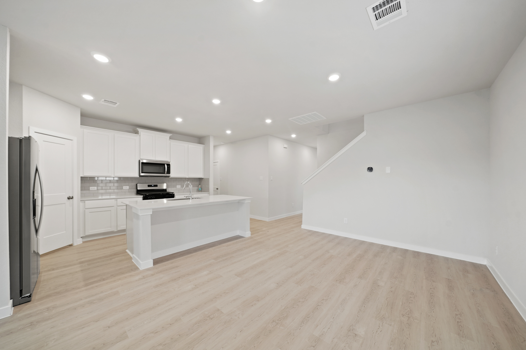 A kitchen with white cabinets.