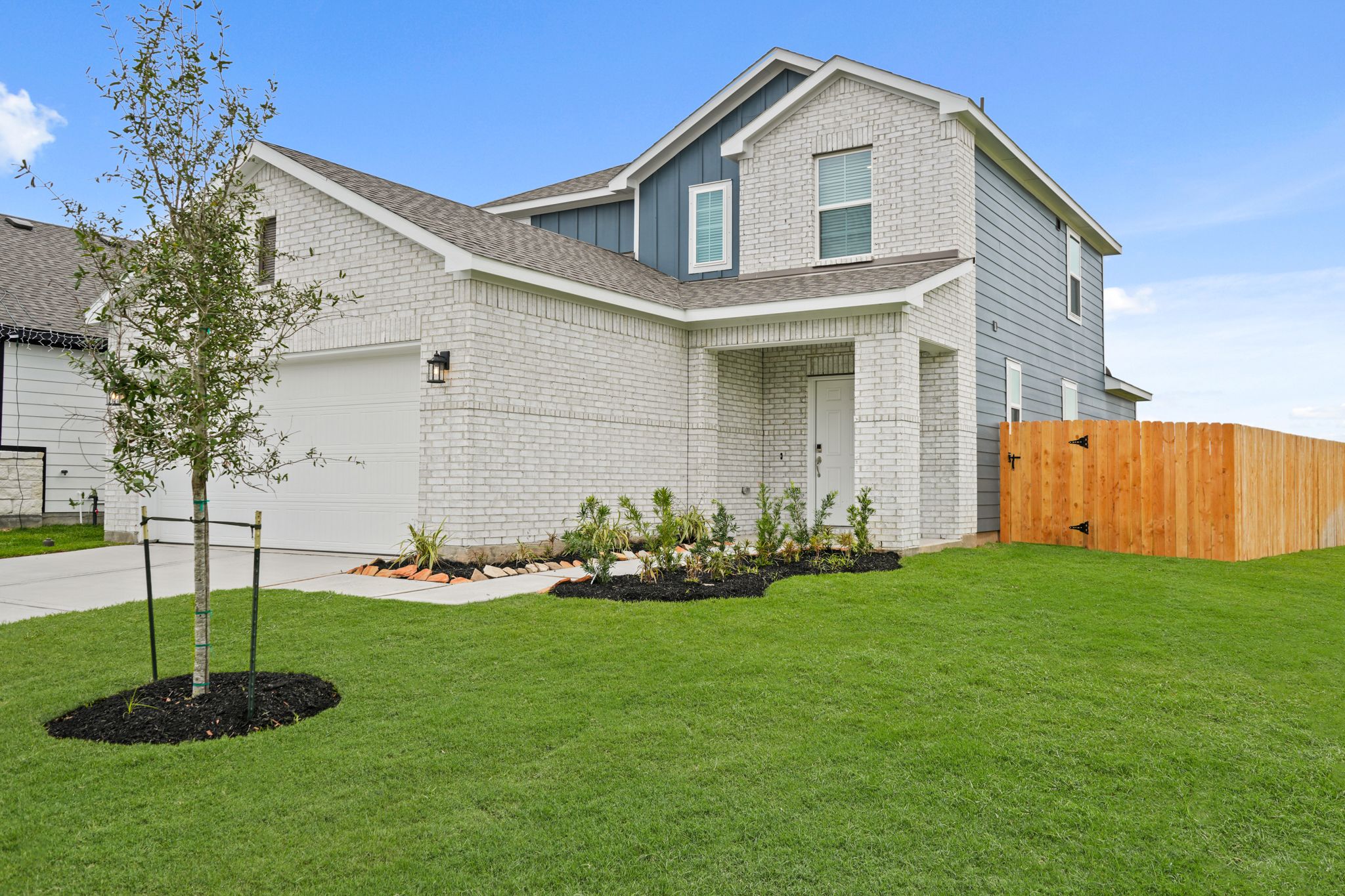 A house with a tree in the front yard.