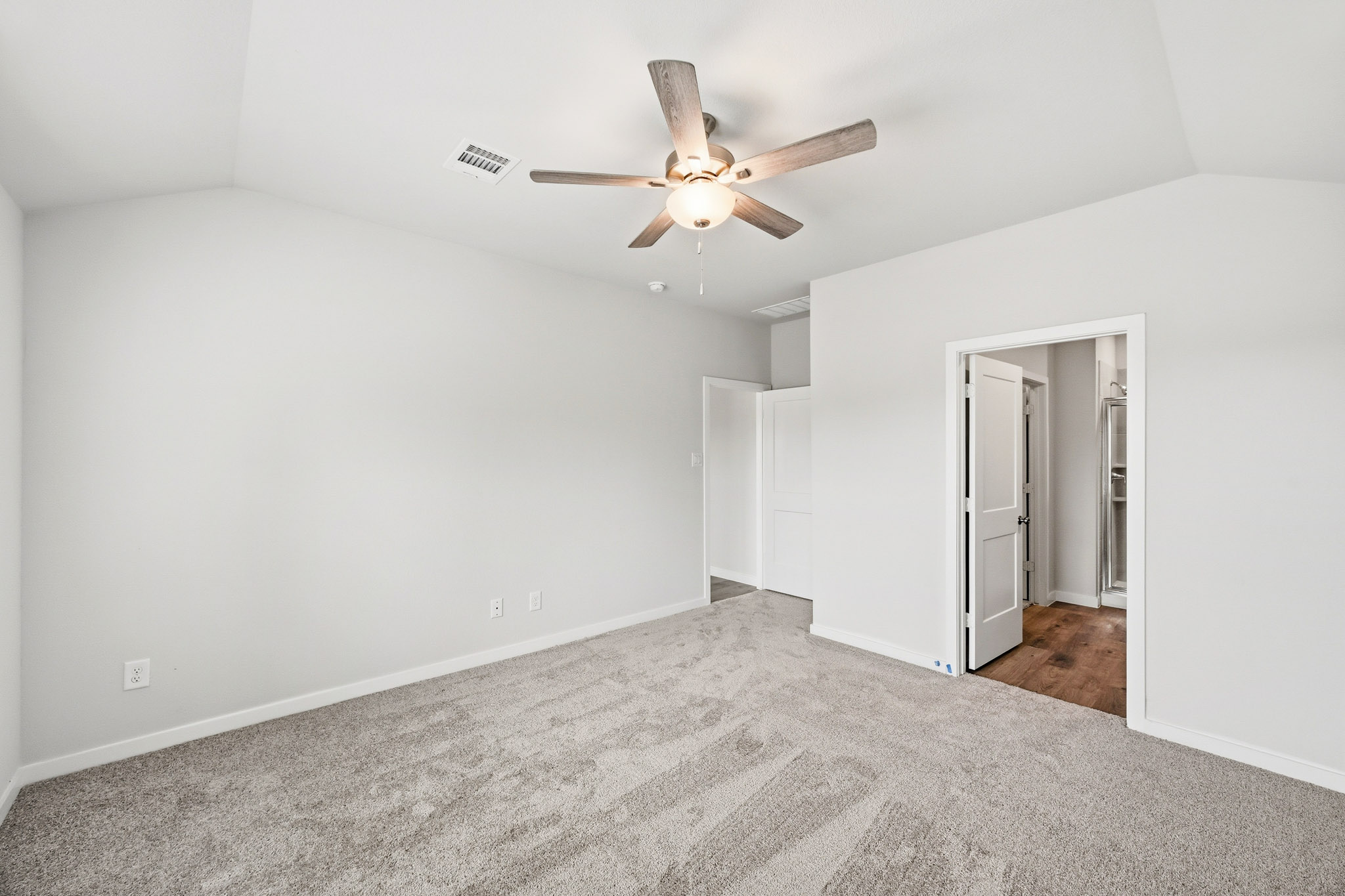 A room with a ceiling fan and a door.