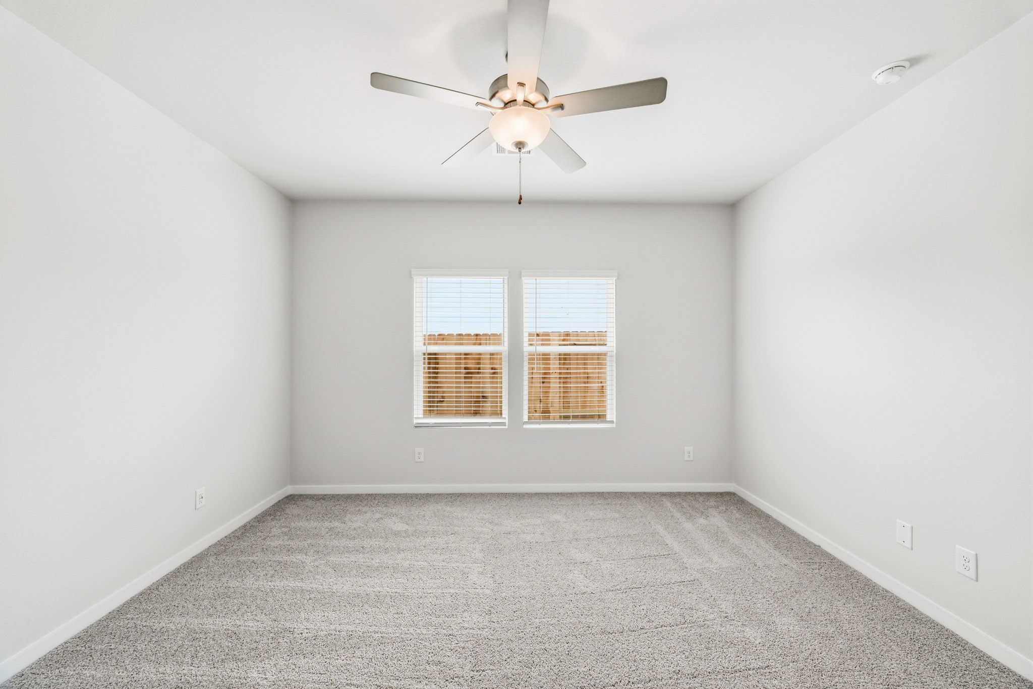 A room with a ceiling fan and a window.