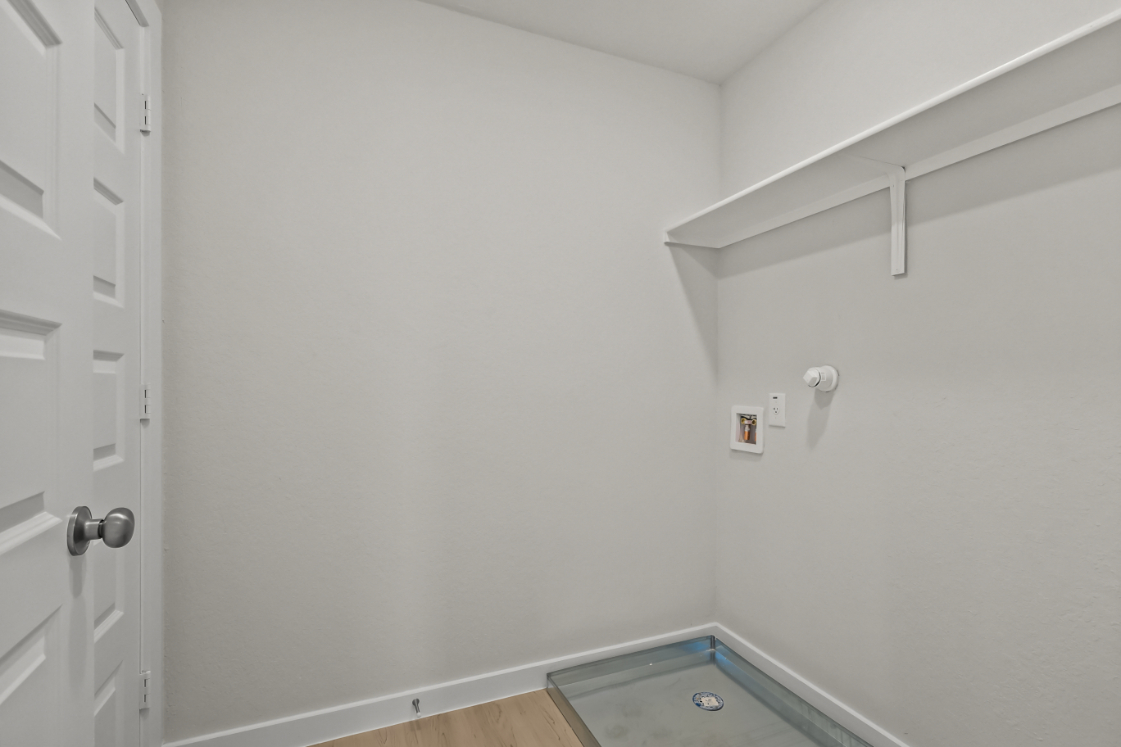 A white wall with a door and a white door.