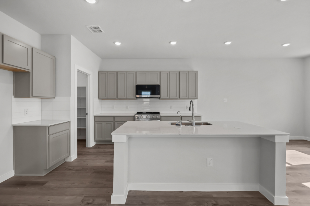 A kitchen with white cabinets.