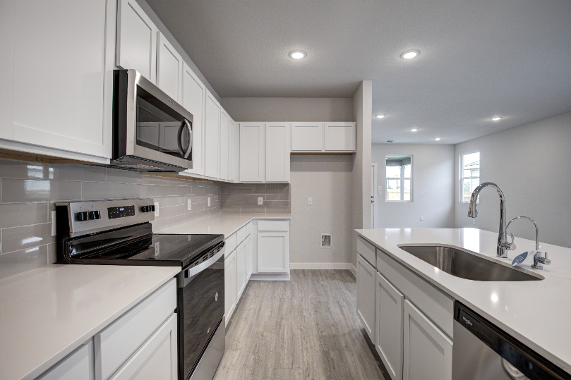 A kitchen with white cabinets.