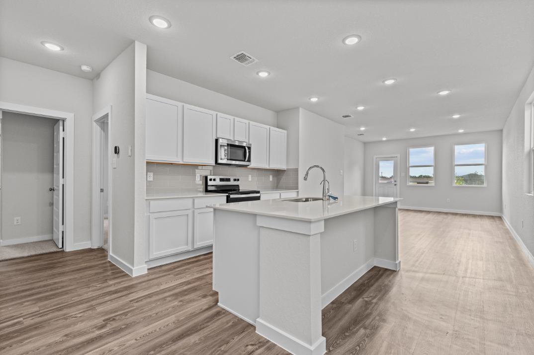 A kitchen with white cabinets.