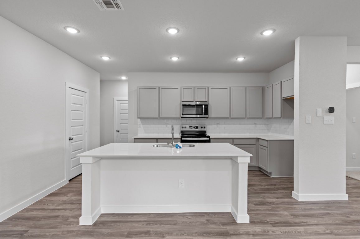 A kitchen with white cabinets.