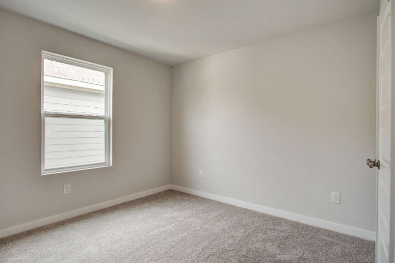 A room with a window and carpet.