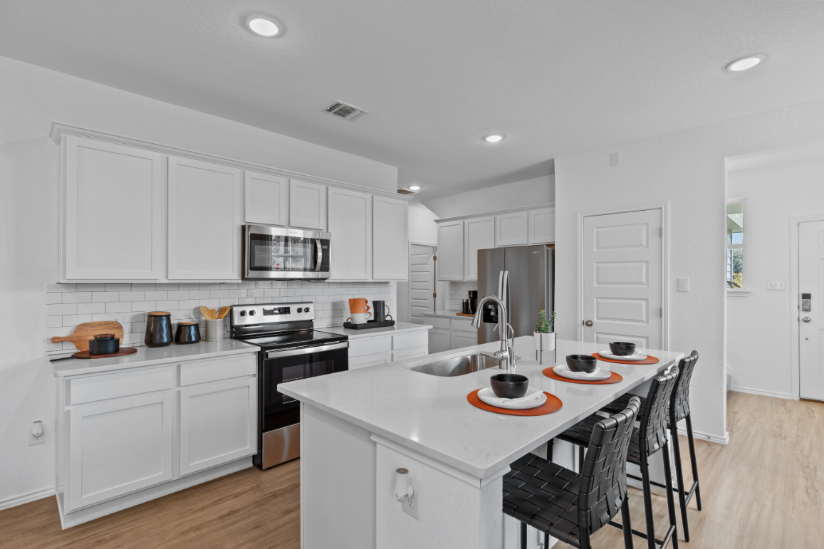 A kitchen with white cabinets.