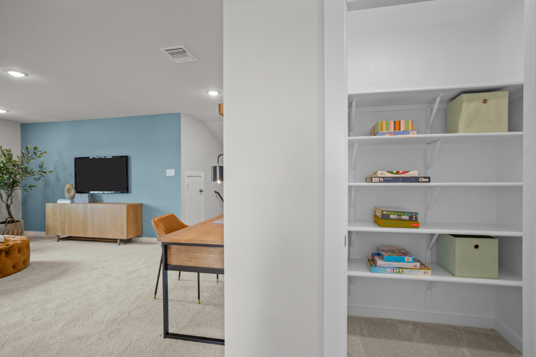 A room with a desk and shelves.