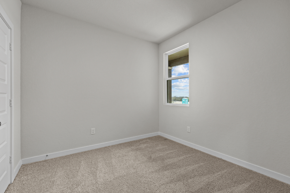 A room with a window and carpet.