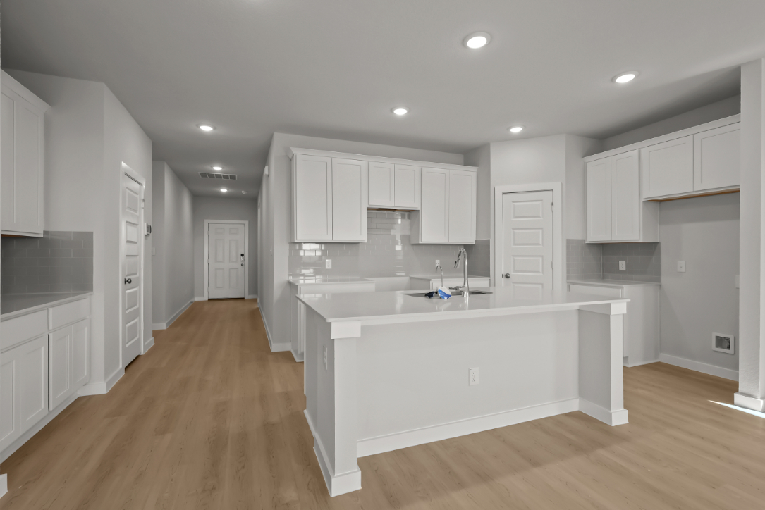 A kitchen with white cabinets.