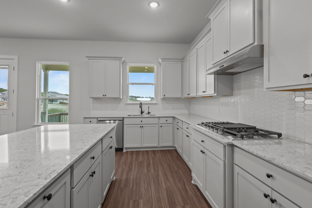 A kitchen with white cabinets.