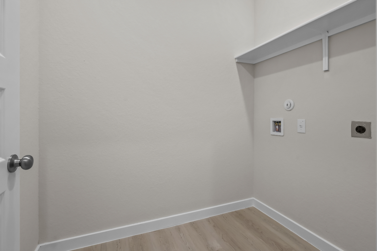 A white wall with a light switch.
