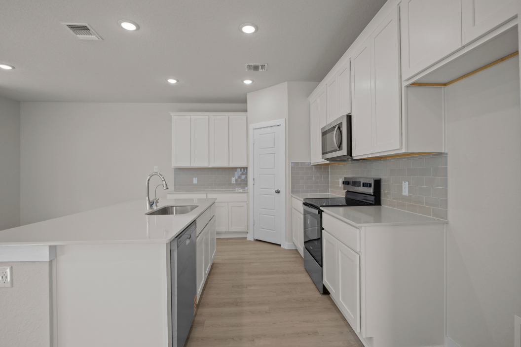 A kitchen with white cabinets.