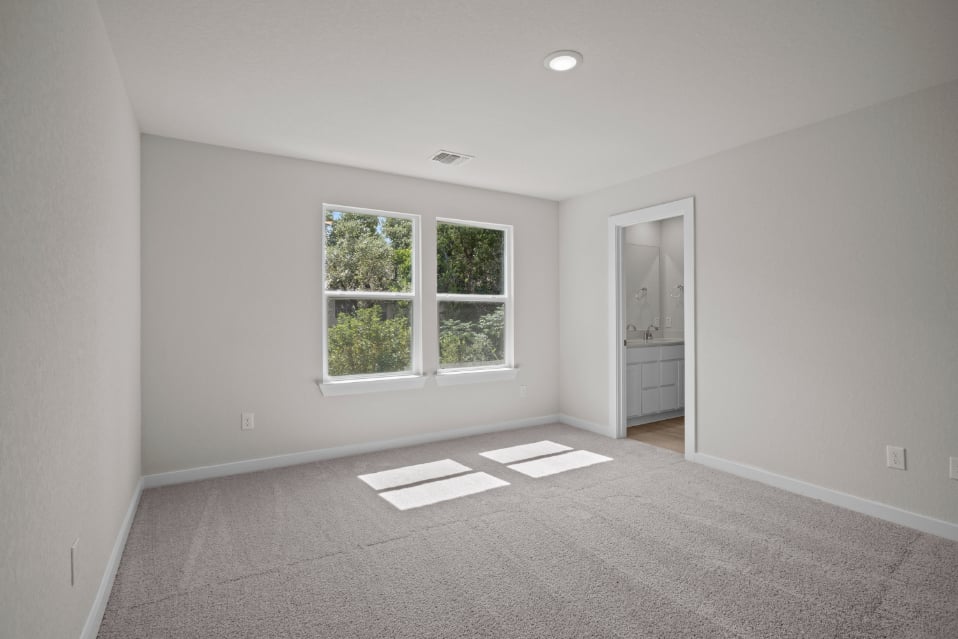 A room with a window and a rug.