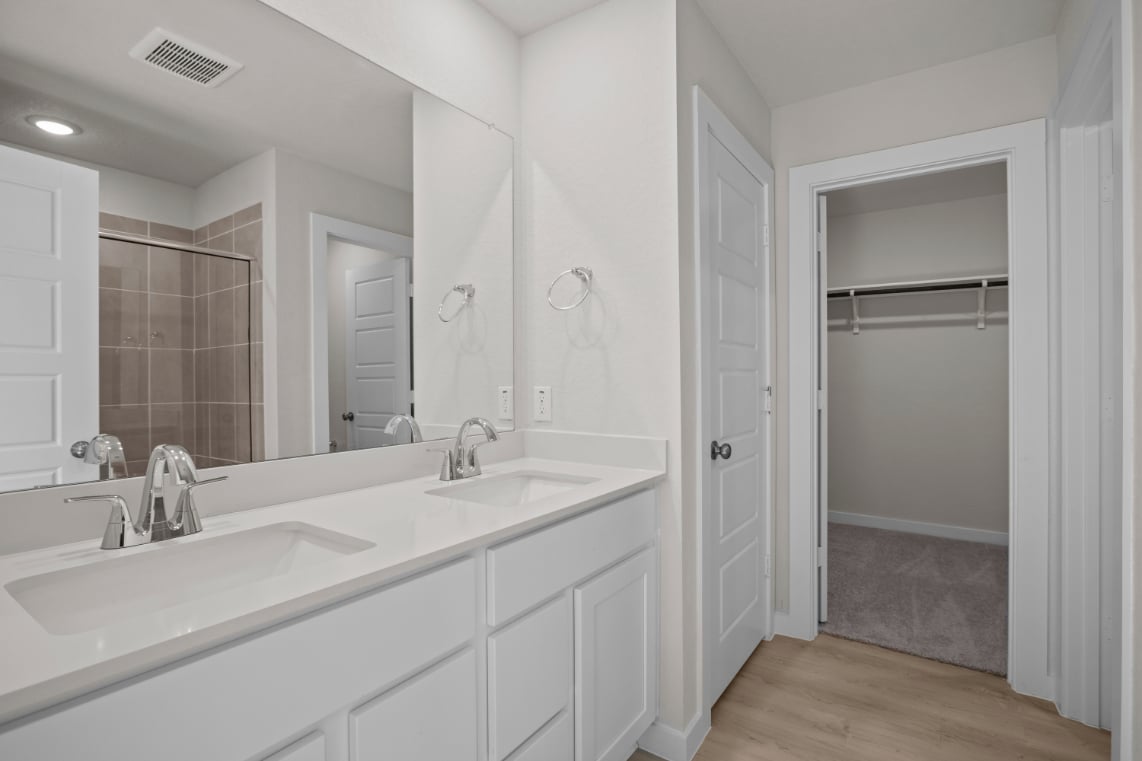 A bathroom with white cabinets.