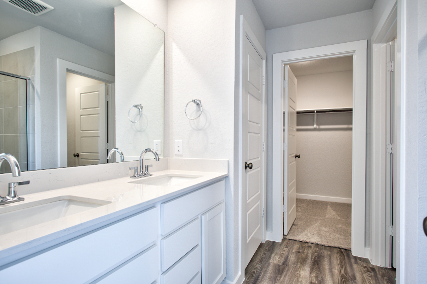 A bathroom with white cabinets.