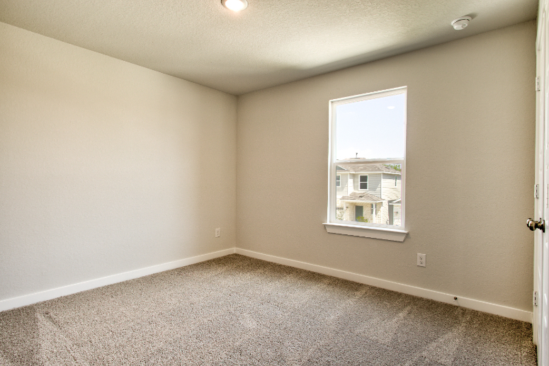A room with a window and carpet.
