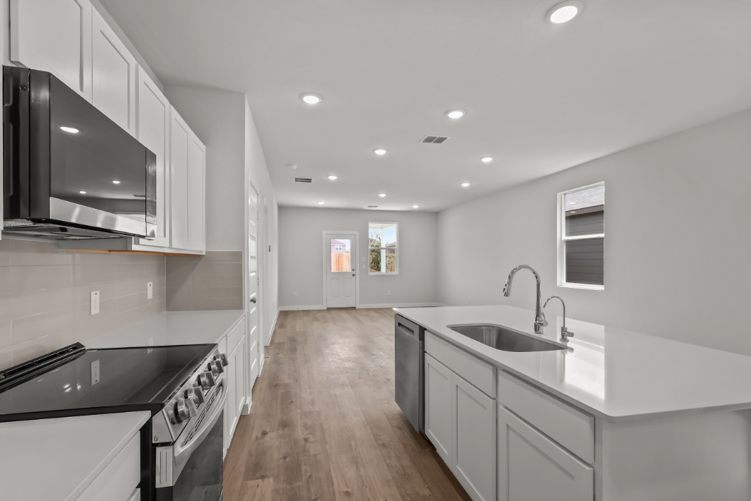 A kitchen with white cabinets.