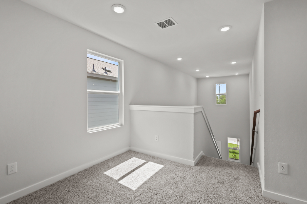A room with a rug and a window.