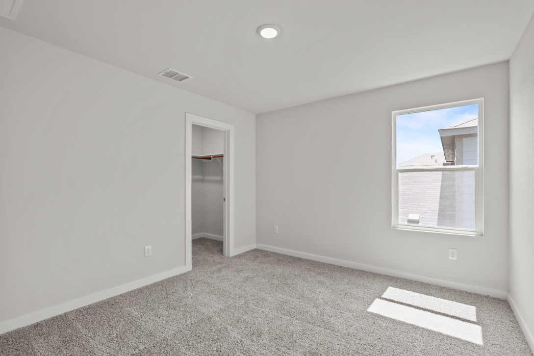 A room with a window and a rug.