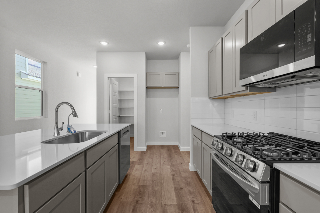 A kitchen with white cabinets.