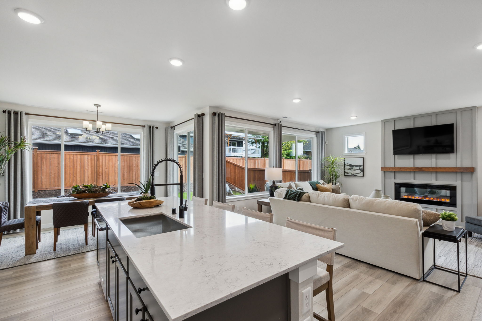 A large living room with a large white table and a large window.