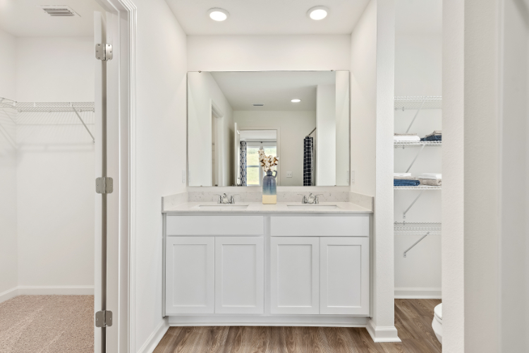 A bathroom with white cabinets.