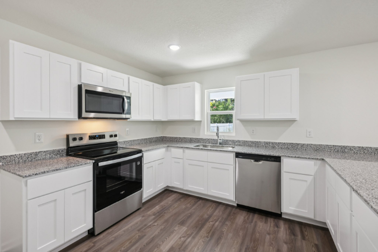 A kitchen with white cabinets.