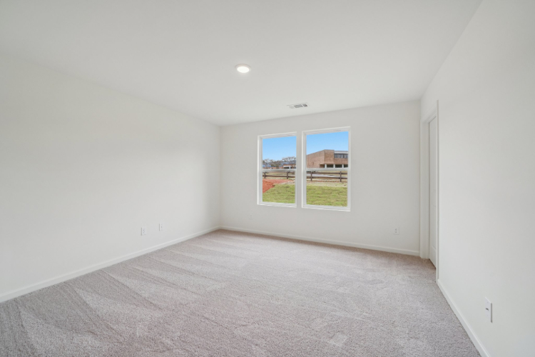A room with a window and a carpet.
