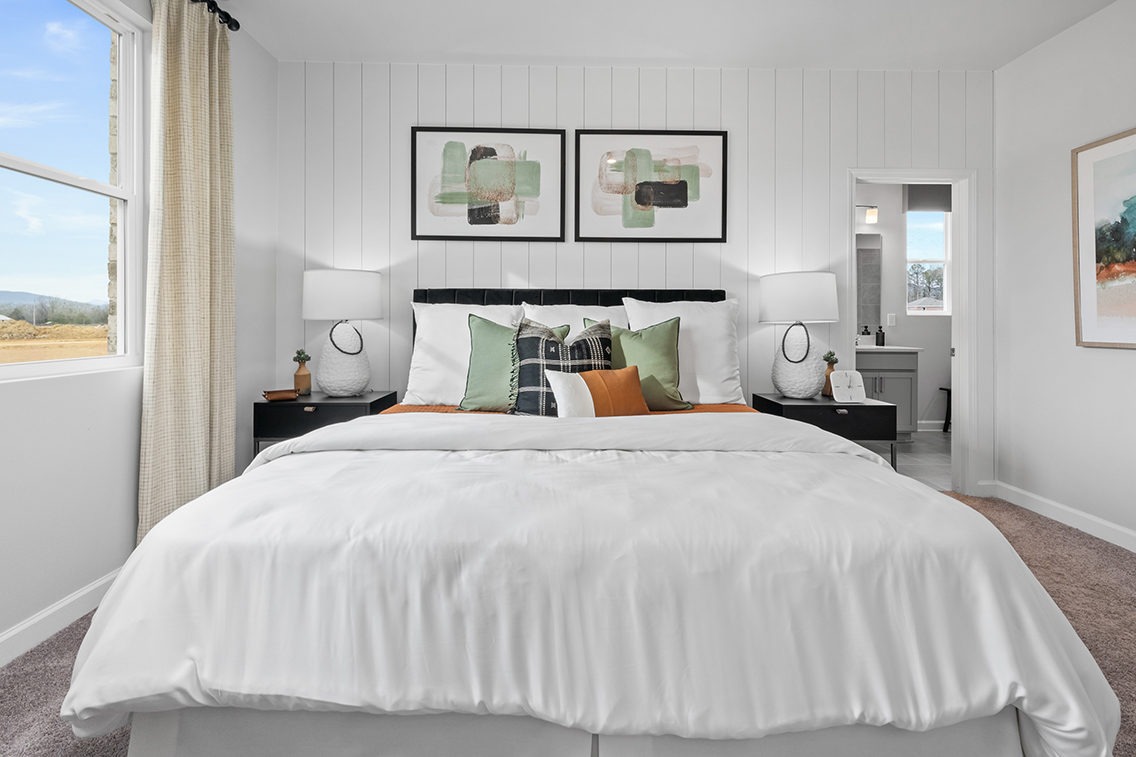 A bed with a white bed spread.