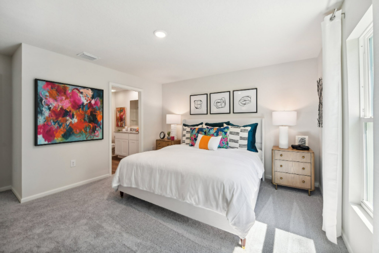 A bedroom with a bed and a lamp.