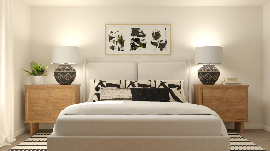 A white couch with a black and white pillow and a white lamp.