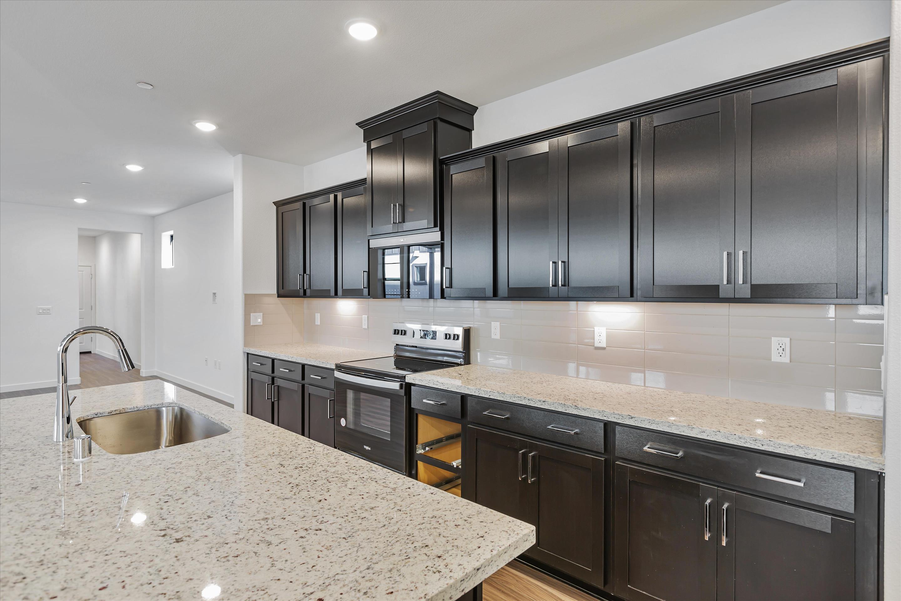 A kitchen with black cabinets.