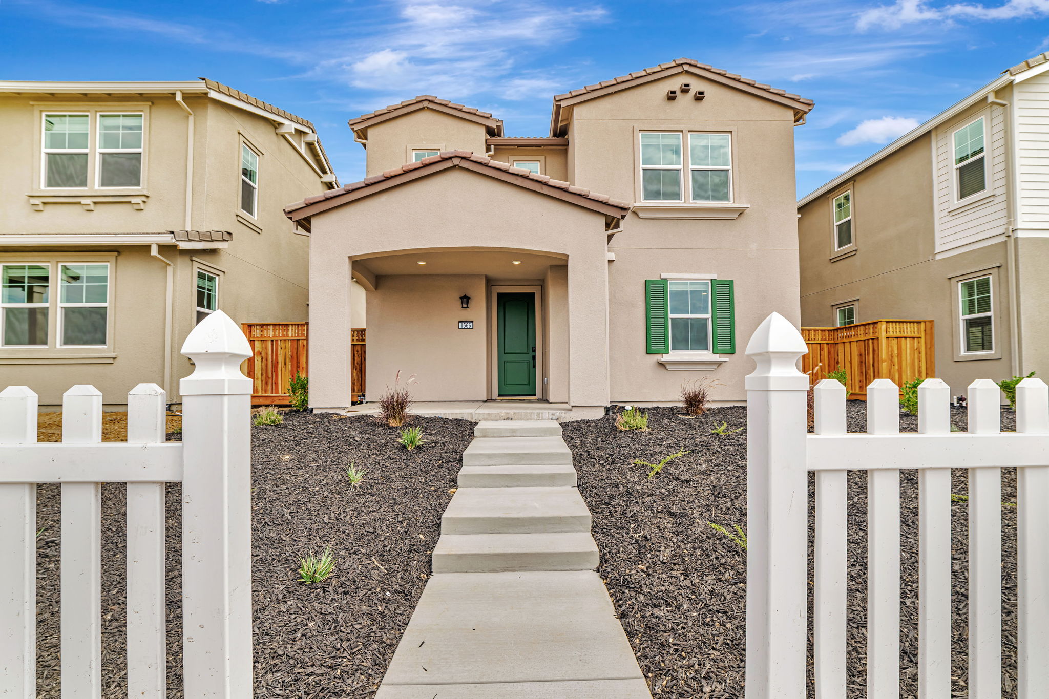 A white fence in front of a house.